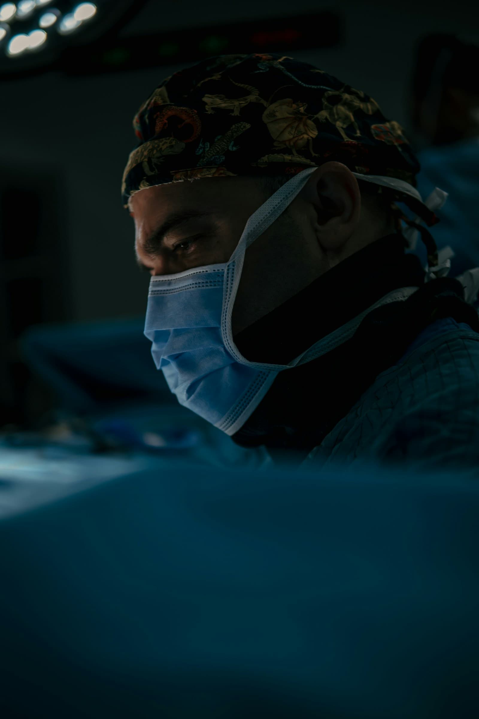 Full-bleed vertical portrait of Op. Dr. Alper Aras. Editorial-clinical, low-key lighting, 4:5 crop.